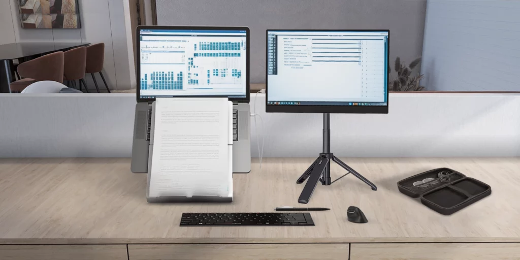 A modern workspace featuring the Standivarius X-Stand, holding a portable monitor alongside a laptop for an ergonomic dual screen productivity setup.